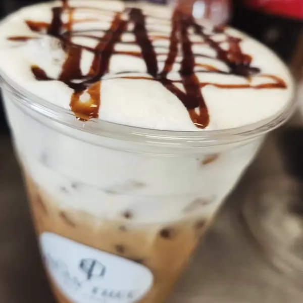 Iced latte with thick cold foam and a crosshatched chocolate drizzle